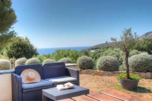 a blue couch with a hat on a table at Les Oliviers CENTURI-PORT in Centuri