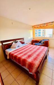 een slaapkamer met een groot bed en een rode deken bij Salinas-Chipipe Dpto 3 hbts amoblado in Salinas