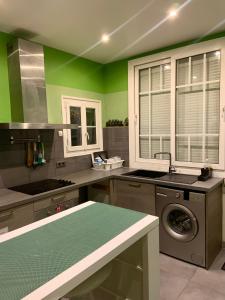 uma cozinha com paredes verdes e uma máquina de lavar roupa em Chambre charmante entre Paris et Disney em Noisy-le-Grand