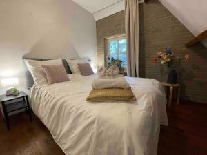 a bedroom with a large white bed with towels on it at Stunning Catena Property in Boxtel