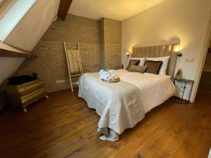 um quarto com uma cama grande e uma parede de tijolos em Stunning Catena Property em Boxtel