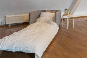 a large bed in a room with a table at Stunning Catena Property in Boxtel