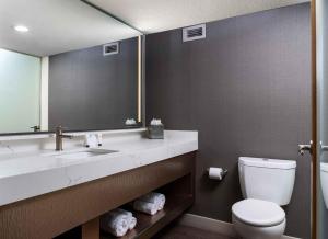 uma casa de banho com um lavatório, um WC e um espelho. em The STRAT Hotel, Casino & Tower em Las Vegas