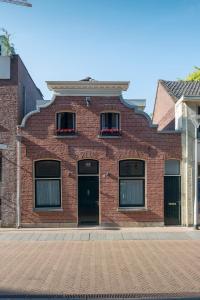 a red brick building with two windows and a door at Lovely Suite Newly Renovated in Tilburg