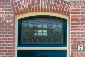 una ventana en un edificio de ladrillo con una puerta en Lovely Suite Newly Renovated, en Tilburg