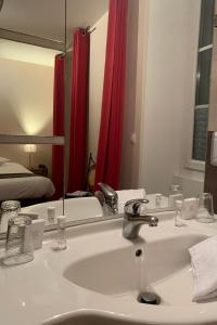 W łazience znajduje się umywalka i lustro. w obiekcie AUBERGE DU PORCHE w mieście Blaye