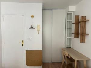 パリにあるstudio trocaderoの白いドアと木製テーブルが備わる部屋