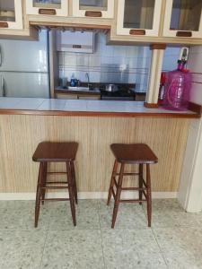 a kitchen with two wooden stools in front of a counter at Tu_refugio_playero in Caraballeda