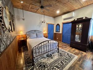 een slaapkamer met een bed en een blauwe deur bij The Russ House in Tombstone