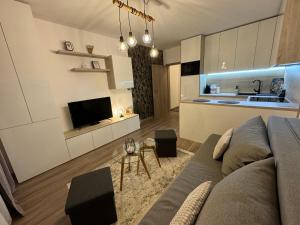 uma sala de estar com um sofá e uma cozinha em Moderný apartmán s výhľadom na Vysoké Tatry em Poprad