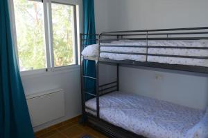 two bunk beds in a room with a window at Preciosa casa cerca del mar in La Redondela