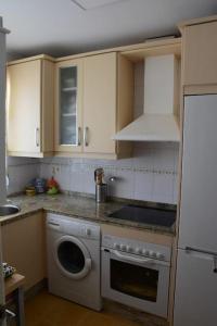 a kitchen with a washing machine and a sink at Preciosa casa cerca del mar in La Redondela