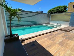 a swimming pool with a palm tree next to a building at Prince Hotel in Santa Cruz de la Sierra