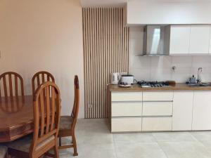 cocina con mesa, 2 sillas, mesa y mesa en Casa Moro Valle de Uco-Tupungato-Mendoza, en Tupungato