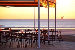 a group of tables and chairs on the beach at Lagoon Beach 29A by Host Agents in Cape Town