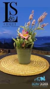 a bouquet of flowers in a green vase on a table at Chalet Laguna Sagrada de Fuquene in Fúquene