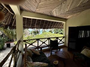 a living room with a couch and a large window at Villa Maua Exclusive in Matemwe