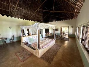 ein Schlafzimmer mit einem Himmelbett in einem Zimmer in der Unterkunft Villa Maua Exclusive in Matemwe