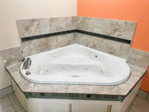 a large white bath tub in a bathroom at Pecan Valley Inn & Suites in San Antonio