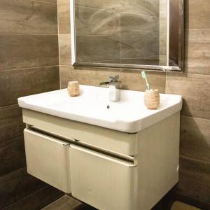 ein Badezimmer mit einem weißen Waschbecken und einem Spiegel in der Unterkunft Travelholics Getaways in Piarco