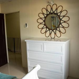 a white dresser with a mirror on a wall at Travelholics Getaways in Piarco