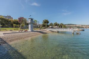 a bridge over a body of water with people sitting on the shore at Istrabella Apartment in Koper