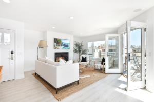 Una sala de estar con un sofá blanco y una chimenea. en Luxury 3 Bedroom walk to Beach & Pier, en Newport Beach