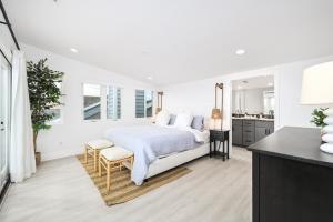 Un dormitorio blanco con una cama y una cocina. en Luxury 3 Bedroom walk to Beach & Pier, en Newport Beach