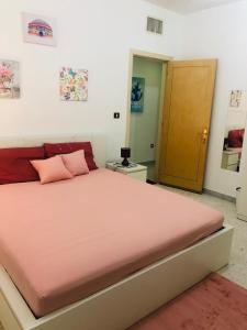 een slaapkamer met een groot bed met roze kussens bij A103 Cozy Private Room Shared Apartment Muroor Abu Dhabi UAE in Abu Dhabi