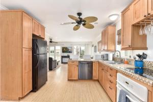 uma cozinha com armários de madeira e um frigorífico preto em 4 Bedroom Home with Rooftop & Peek-A-Boo Ocean View em Newport Beach