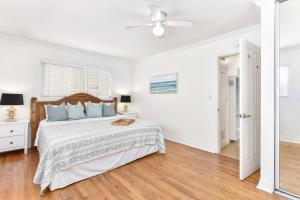 um quarto branco com uma cama e uma ventoinha de tecto em 4 Bedroom Home with Rooftop & Peek-A-Boo Ocean View em Newport Beach