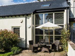 a patio with a table and an umbrella at Lark Meadow in Carnforth