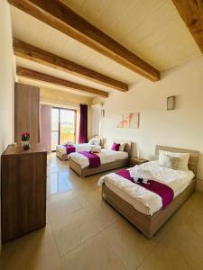 a large room with two beds and a couch at Dawlet ix-Xemx Gozo Farmhouse in Kerċem