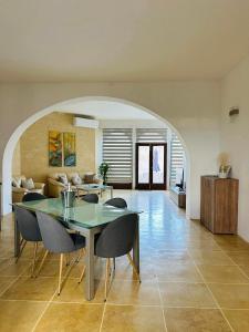 a dining room with a table and chairs in a room at Dawlet ix-Xemx Gozo Farmhouse in Kerċem