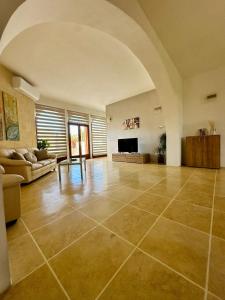 a large living room with a couch and a fireplace at Dawlet ix-Xemx Gozo Farmhouse in Kerċem