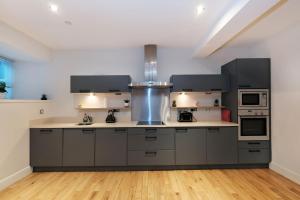 - une cuisine avec des placards gris et un évier dans l'établissement One of a kind Historic 3 bedroom apartment, à Aberdeen
