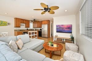 uma sala de estar com um sofá e uma mesa em Freshly Renovated Beach House Steps to the Beach em Newport Beach