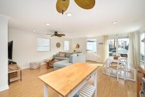 uma sala de estar com um sofá e uma mesa em Freshly Renovated Beach House Steps to the Beach em Newport Beach