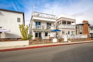 uma casa branca ao lado de uma rua em Freshly Renovated Beach House Steps to the Beach em Newport Beach