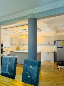 eine große Küche mit zwei blauen Stühlen in einem Zimmer in der Unterkunft Short And Long Stay Six Bedroom Apartment in Tema