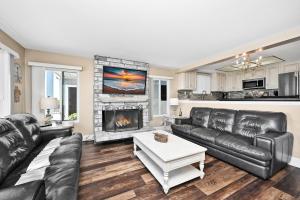 a living room with leather furniture and a fireplace at Newport Paradise - Oceanfront Home by the Pier in Newport Beach