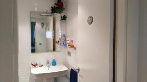 a white bathroom with a sink and a mirror at Apartaments Oller 2 in Roses