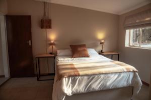 une chambre avec un lit avec deux lampes sur deux tables dans l'établissement Eco Farm Cottage, à Millvale