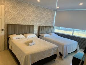2 camas en una habitación con ventana en Borabora hotel en San Andrés