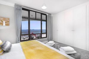 a bedroom with a bed and a large window at Witsand 804 by Host Agents in Bloubergstrand