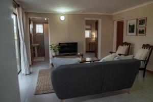 un salon avec un canapé et une télévision dans l'établissement Eco Farm Cottage, à Millvale