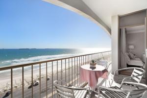 a balcony with a table and chairs and the beach at Witsand 804 by Host Agents in Bloubergstrand