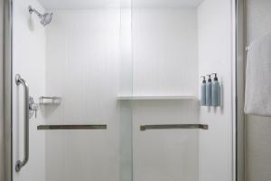 a bathroom with a shower with a glass door at Courtyard by Marriott - Naples in Naples
