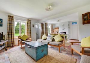 a living room with a couch and a table at BackToFront Cottage in Briston