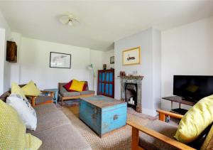 a living room with a couch and a fireplace at BackToFront Cottage in Briston